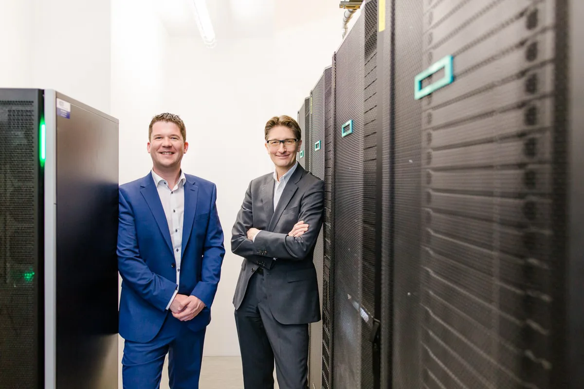 Peter Reisinger von EPS und Ing. Gregor Teichmann von VOR-Verkehrsverbund Ost-Region stehen nebeneinander im Serverraum