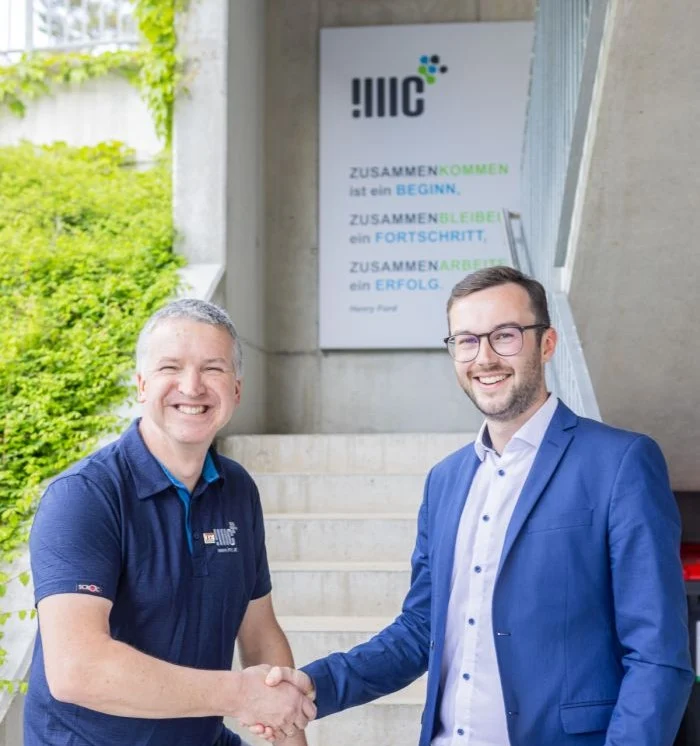 Thomas Knapp von IMC und Michael Kainrath von EPS schuetteln die Hand vor dem Buerogebaeude in Ybbsitz