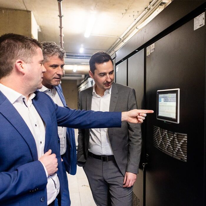 Peter Reisinger von EPS zeigt Manuel Staber und Dejan Vlajic die IT-USV-Anlagen, die fuer eine energieeffiziente Stromversorgung sorgen