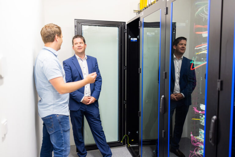 Georedundante Rechenzentrumslösung für SAN Group 4 Andreas Hahn mit Peter Reisinger vor einem IT Serverrack mit regulierbarer Kaltluftzuführung und integrierter Kalt,- Warmgangtrennung