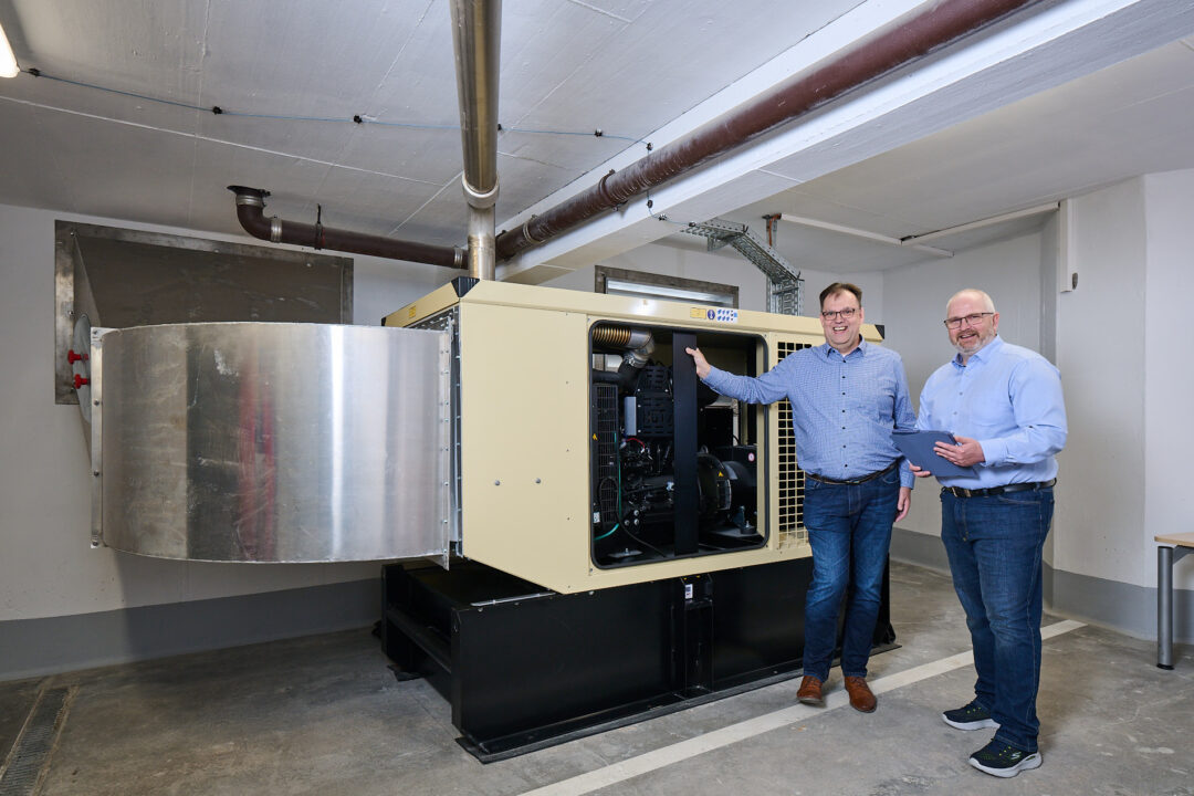 Peter Rupprecht, IT administrator and project manager in IT management at Volksbank Raiffeisenbank Nordoberpfalz eG with colleague Bruno Durst in front of the emergency power generator of the company EPS