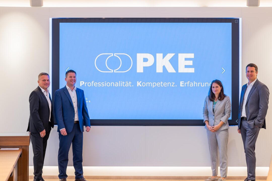 Serverraum Spezialist EPS realisiert mobilen High-Cube DC Container für PKE 2 Manfred Jiras, Peter Reisinger, Stefanie Gutleder und Matthias Koppensteiner stehen vor einer Wandprojektion von PKE