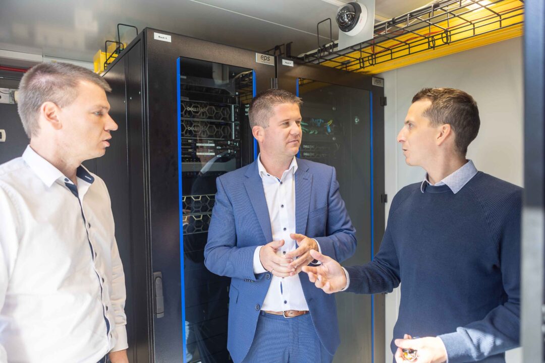 Serverraum Spezialist EPS realisiert mobilen High-Cube DC Container für PKE 4 Peter Goebl, IT-Mitarbeiter bei PKE, Peter Reisinger, Vertriebsleiter bei EPS, und André Titz, IT-Manager bei PKE stehen im Datacenter Container vor einem Serverschrank