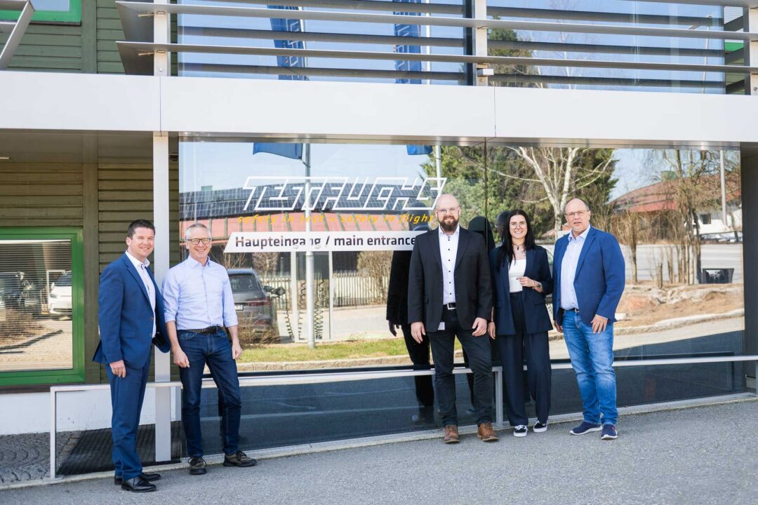 Peter Reisinger, Geschaeftsfuehrer von EPS, Volker Fuchs, Geschaeftsfuehrer von TEST-FUCHs, Bernhard Weber, IT-Infrastruktur von TEST-FUCHS, Anna Weixlbraun, Support Projektmanagement von EPS, und Christopher Ferkl, IT-Leiter bei TEST-FUCHS stehen vor dem Eingang des Hauptgebaeude in Gross-Siegharts.