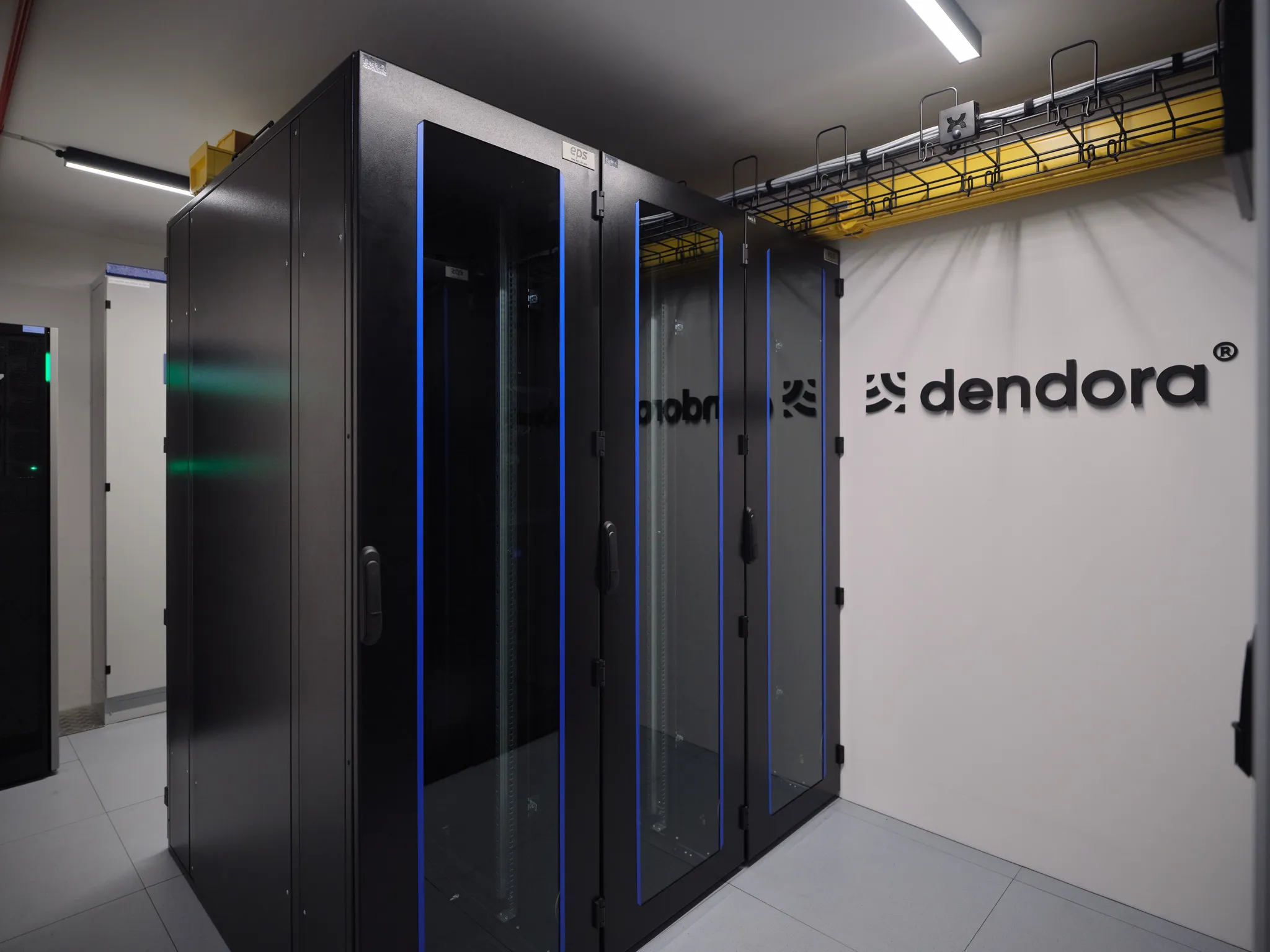 Dendora Serverraum mit dendora Logo im Hintergrund